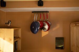 Hanging pots in a warm-toned kitchen, showcasing a practical and organized cooking space.