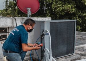 Technician performing ductless AC repair on rooftop unit, emphasizing expert HVAC service and maintenance for home comfort.
